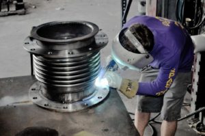 WeldingExpansionJoint1 An employee of Spartan Industrial Marine is welding a 12" metal expansion joint in their hose and fittings shop in Houma, LA.